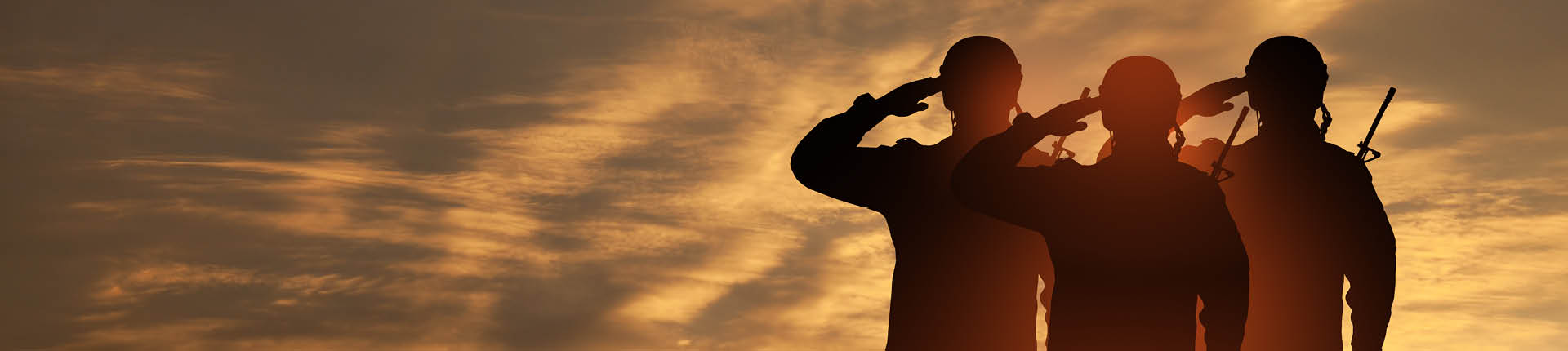 A silhouette of 3 soldiers heading